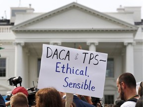 A person holds up a sign in support of the Deferred Action for Childhood Arrivals, known as DACA, and Temporary Protected Status programs during a rally in support of DACA and TPS outside of the White House, in Washington, Tuesday, Sept. 5, 2017. The programs protected a number of groups from deportation.