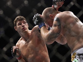 In this April 27, 2013, file photo, Michael Bisping, left, fights Alan Belcher during their UFC 159 mixed martial arts middleweight bout in Newark, N.J. Although Georges St. Pierre has been out of the UFC for 3 1/2 years, the Canadian is still one of the biggest names in MMA. The longtime welterweight champ's comeback fight later this year will be for Bisping's middleweight belt.