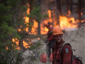 A B.C. Wildfire Service firefighter looks on while conducting a controlled burn to help prevent the Finlay Creek wildfire from spreading near Peachland, B.C., on Thursday, September 7, 2017.
