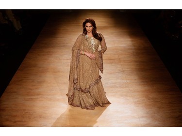 Bollywood actress Huma Qureshi presents a creation by Indian fashion designers Rimple and Harpreet Narula during the India Couture Week 2014 in New Delhi on July 20, 2014.