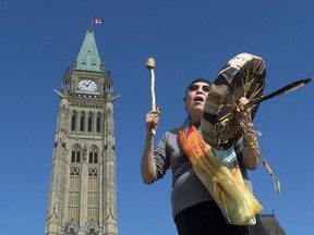 Chief Marcia Brown Martel sings outside the parliament buildings following a government news conference announcing a compensation package for indigenous victims of the sixties scoop, in Ottawa on Friday, October 6, 2017.