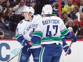 Brock Boeser of the Vancouver Canucks celebrates his first period power-play goal against the Ottawa Senators with teammate Sven Baertschi .