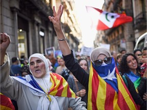 Madrid And Barcelona Vie For Control In Catalan Crisis

BARCELONA, SPAIN - OCTOBER 28:  Moroccan Rif activists wrap themselves in a Catalan flag during a demonstration outside the Palau Catalan Regional Government Building on October 28, 2017 in Barcelona, Spain. The Spanish government stripped Catalonia of its autonomy following the Catalan parliament's vote yesterday to declare independence.