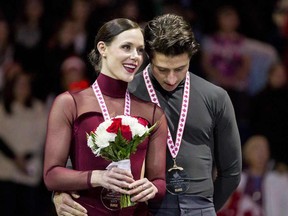Ice dance gold medalists Tessa Virtue and Scott Moir sing the national anthem during the medal ceremony at the 2017 Skate Canada International event in Regina on Oct. 28, 2017.