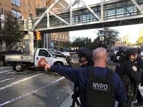 In this photo provided by the New York City Police Department, officers respond to a report of gunfire along West Street near the pedestrian bridge at Stuyvesant High School in lower Manhattan in New York, Tuesday, Oct. 31, 2017.