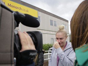 Kelly Hall, a cabin crew member for Monarch Airlines, wipes a tear as she reacts to news she has lost her job with the airline, at Luton Airport in Luton, England, Monday, Oct. 2, 2017.