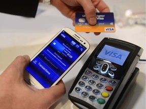 A man uses the NFC payment Visa system at the Mobile World Congress, the world's largest mobile phone trade show, in Barcelona, Spain, in 2013. Payment processing giant Visa is launching a platform to allow banks to integrate various types of biometrics, such as your fingerprint, face, voice, etc., into approving credit-card applications and payments. It could lead to customers having to take a selfie to verify they actually made an online purchase or applied for a particular credit card.