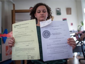 Stand.earth (formerly Forest Ethics) campaign associate Hayley Zacks holds a copy of a notice of civil enforcement and a federal court of appeal ruling delivered to their office by a bailiff notifying them of the seizure of assets relating to a $14,559.19 judgement owing to Enbridge from a Line 9 pipeline court challenge, in Vancouver on Tuesday, October 17, 2017.