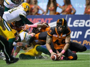B.C. Lions' Mike Benson, right, picks up the ball and runs it in for a touchdown after Edmonton Eskimos' Brandon Zylstra, left, fumbled the ball on a kick return during the second half of a CFL football game in Vancouver, B.C., on Saturday October 21, 2017.