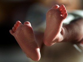 In this file photograph, a two-week-old boy finds his feet in his new world.