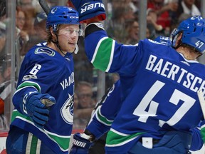 Brock Boeser celebrates with Vancouver Canucks teammate Sven Baertschi after scoring during Saturday's game against the Calgary Flames at Rogers Arena.