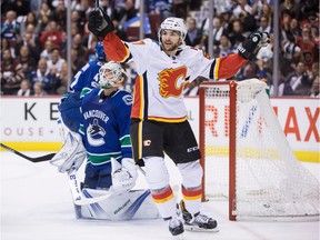 Calgary Flames' Michael Frolik celebrates a goal by teammate Dougie Hamilton in front of Canucks goalie Jacob Markstrom during third-period NHL action in Vancouver on Saturday.