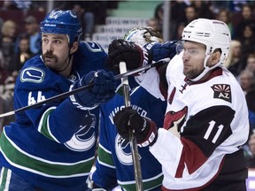 Vancouver Canucks defenceman Erik Gudbranson (left) tries to clear Arizona Coyotes centre Martin Hanzal from in front of the Canucks net during first period NHL action in Vancouver, B.C. Thursday, Nov. 17, 2016. Gudbranson is part of a dwindling group of players in the NHL that still chooses to play without a visor.