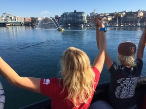 Participants in the Canada C3 expedition join hands as they enter Victoria's inner harbour to a jubilant welcome on Saturday morning.