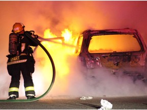 Firefighters work to put out a blaze in a vehicle linked to a double targeted shooting in Surrey on Friday night.
