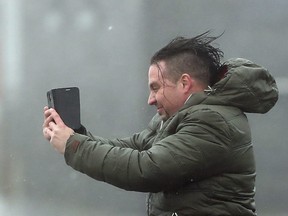 A man take selfie in the high wind at Lahinch on the west coast of Ireland Monday Oct. 16, 2017, as the remnants of Hurricane Ophelia begins to hit Ireland and parts of Britain.