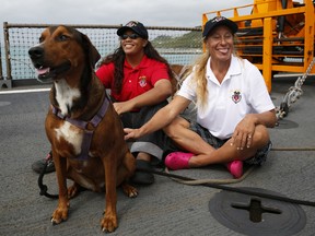 Jennifer Appel, right, and Tasha Fuiava sit with their dogs on the deck of the USS Ashland Monday, Oct. 30, 2017, at White Beach Naval Facility in Okinawa, Japan.