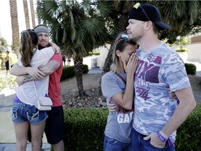 Sean Bean, of Livermore, Calif., hugs his girlfriend Katie Kavetski, of San Leandro, Calif., left, as Travis Reed, of Mexico, Ind., right, comforts his girlfriend Anna Travnicek, second from right, on Las Vegas Strip, Monday, Oct. 2, 2017, in Las Vegas. All attended a concert where a mass shooting occurred on Sunday.