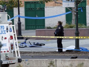 A New York Police Department officer stands next to a body covered under a white sheet near a mangled bike along a bike path Tuesday Oct. 31, 2017, in New York. Police are responding to a report of gunfire a few blocks from the World Trade Center site and memorial, and witnesses say a vehicle drove down a popular bike path and struck pedestrians and cyclists. (AP Photo/Bebeto Matthews) ORG XMIT: NYBM104
Bebeto Matthews, AP