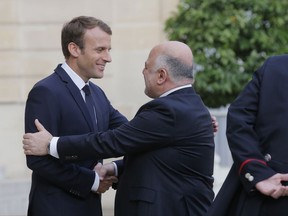 French President Emmanuel Macron, left, welcomes Iraqi Prime Minister Haider al-Abadi at the Elysee Palace in Paris, Thursday, Oct. 5, 2017. Iraqi Prime Minister Haider al-Abadi is meeting with French President Emmanuel Macron in Paris for talks on the international fight against Islamic State group extremists and rebuilding Iraq's economy. (AP Photo/Michel Euler)