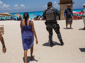 A federal Police officer patrols a beach in Cancun on July 11.