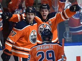 Connor McDavid celebrates with Oilers teammates Oscar Klefbom and Leon Draisaitl after scoring his first goal of the game against the Calgary Flames during their season opener at Rogers Place in Edmonton on Wednesday night.