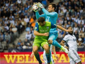 Whitecaps' Nosa Igiebor, left, controls the ball in front of Seattle Sounders' Jordy Delem during the first half of an MLS playoff soccer game in Vancouver, B.C., on Sunday October 29, 2017.