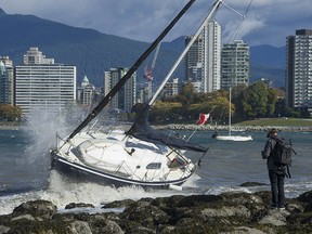 Waves and heavy wind pound a unmoored sailboat that washed ashore at Kits Point in Vancouver, Tuesday, October 17, 2017. The Lower Mainland has been hit by the first storm of the season causing power outages and wet, soggy and windy conditions.  (Photo by / PNG) (For