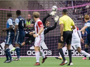 Vancouver Whitecaps' goalkeeper Stefan Marinovic, back, dives to make a save against the San Jose Earthquakes in MLS action on Oct. 15. His stellar play has made the team's starting job in net a point of debate.