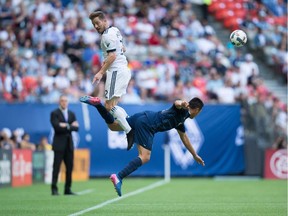 Vancouver Whitecaps' Jordan Harvey, left, and Sporting Kansas City's Roger Espinoza vie for the ball during the first half of an MLS soccer game in Vancouver, B.C., on Saturday, May 20, 2017.