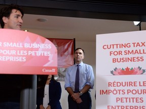 Federal Finance Minister Bill Morneau looks on as Prime Minister Justin Trudeau speaks to members of the media at a press conference on tax reforms in Stouffville, Ont., on Monday, Oct. 16, 2017.
