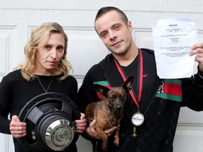 Dustin Hamilton, with his girlfriend, Katrina Jourdenais, and their dog, Luna, holds a sheet that was plastered all over the neighbourhood asking people to complain to police about the noise from his car stereo. The ban is "depressing," Hamilton says.