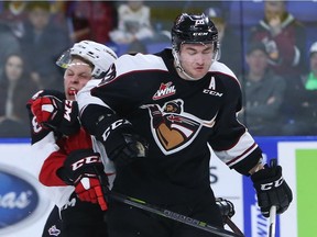 Darian Skeoch of the Vancouver Giants checks Jackson Leppard of the Prince George Cougars during the third period of their WHL game at the Langley Events Centre on October 27, 2017 in Langley.