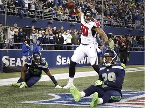 Tight end Levine Toilolo #80 of the Atlanta Falcons spikes the ball to celebrate his 25 yard touchdown as linebacker Terence Garvin #52 of the Seattle Seahawks and Earl Thomas #29 react during the third quarter of the game at CenturyLink Field on November 20, 2017 in Seattle.