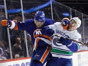 Scott Mayfield of the New York Islanders takes a first period penalty for elbowing Bo Horvat.