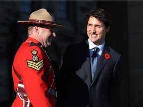 Canadian Prime Minister Justin Trudeau speaks with an RCMP officer before the arrival of the Colombian President Juan Manuel Santos Calderon on Parliament Hill in Ottawa, Ontario, October 30, 2017.