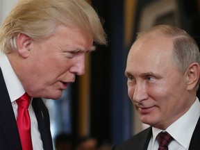 US President Donald Trump (L) chats with Russia's President Vladimir Putin as they attend the APEC Economic Leaders' Meeting, part of the Asia-Pacific Economic Cooperation (APEC) leaders' summit in the central Vietnamese city of Danang on November 11, 2017.