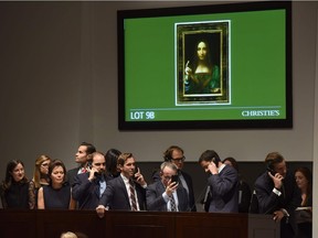 Christie's employees take bids for Leonardo da Vincis "Salvator Mundi" during the Post-War & Contemporary Art Evening Sale at Christie's New York November 15, 2017. A 500-year-old work of art depicting Jesus Christ, believed to be the work of Renaissance master Leonardo da Vinci, sold in New York on Wednesday for $450.3 million setting a new art auction record, Christie's said. "Salvator Mundi," which the auction house dates back to around 1500, sold after 18 minutes of frenzied bidding in a historic sale, the star lot of the November art season in the US financial capital.