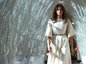 U.S. First Lady Melania Trump walks through Christmas decorations in the East Wing as she tours holiday decorations at the White House in Washington, DC, on November 27, 2017.