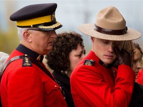 RCMP Const. Ben Oliver, right, wipes away a tear during a regimental funeral for his twin brother Adrian Oliver as his stepfather and fellow Mountie Joe Oliver looks on in Langley on Nov. 20, 2012. Const. Adrian Oliver died on Nov. 13 that year after his unmarked police cruiser collided with a transport truck in Surrey.