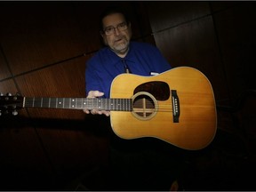 Garry Shrum, a music memorabilia specialist at Heritage Auctions, displays the 1963 Martin D-28 acoustic guitar that belonged to Bob Dylan.