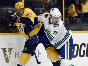 Winger Nikolay Goldobin of the Vancouver Canucks tries to pin Predators' defenceman Mattias Ekholm to the boards during Thursday's NHL action at Bridgestone Arena in Nashville, Tenn. The Canucks finished their six-game road trip in Music City.