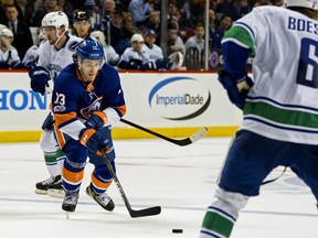 The New York Islanders' Mathew Barzal goes for the puck during the second period of an NHL hockey game against the Vancouver Canucks Tuesday, Nov. 28, 2017, in New York. Right is Vancouver Canucks' Brock Boeser. (