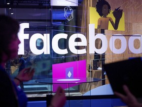 Conference workers speak in front of a demo booth at Facebook's annual F8 developer conference in San Jose, Calif., in April 2017. Facebook is expanding its use of artificial intelligence to help prevent suicides. The social media giant says it’s doing this by scanning people’s posts and live videos to detect if someone might be thinking about harming themselves, before the posts are even reported.