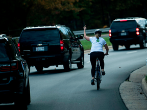 Juli Briskman gives the finger as a motorcade with President Donald Trump leaves Trump National Golf Course in Sterling, Virginia, on Oct. 28, 2017.