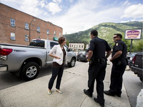 B.C. Energy Minister Michelle Mungall, left, chats with police officers outside of her Nelson-Creston riding office.