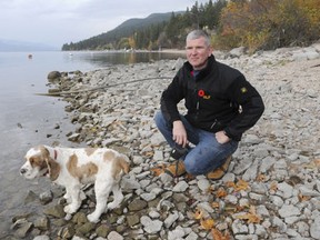 The town of Lake Country is proposing to sell three waterfront properties, totalling a half-hectare in size, for $1.3 million, and put the money toward various municipal purposes. Carr's Landing resident Sean Carr kneels near the properties that could be sold.