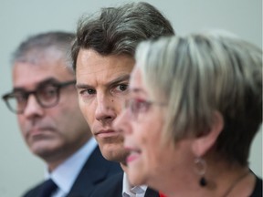 Vancouver Mayor Gregor Robertson, centre, and Dr. Keith Ahamad, back left, an addictions specialist at the BC Centre on Substance Abuse, listen as B.C. Minister of Mental Health and Addictions Judy Darcy speaks during a news conference in Vancouver, B.C., on Friday November 10, 2017. British Columbia is going to test a new drug-checking service in Vancouver to determine if it will help cut the soaring number of overdose deaths in the province. T