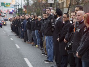 Police, paramedics, sheriffs and other first responders line Grandview Highway in Vancouver, B.C. to pay their respects to Abbotsford police Const. John Davidson as his body is brought back to Abbotsford in a procession of police vehicles, Thursday, November 9, 2017.