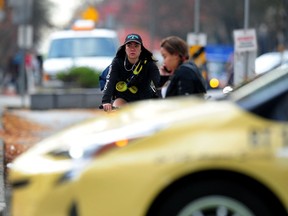 Shot of a woman riding on a bike lane adjacent to traffic in Vancouver on November 1, 2017.